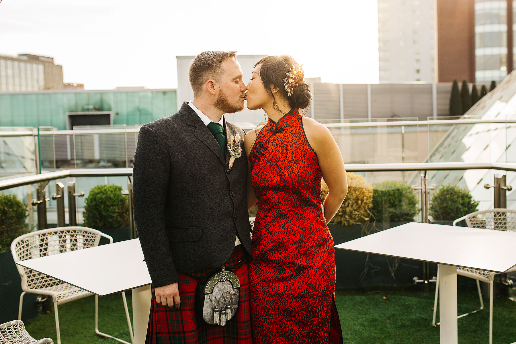A bride and groom kissing on the roof terrace of Crafthouse in Leeds.