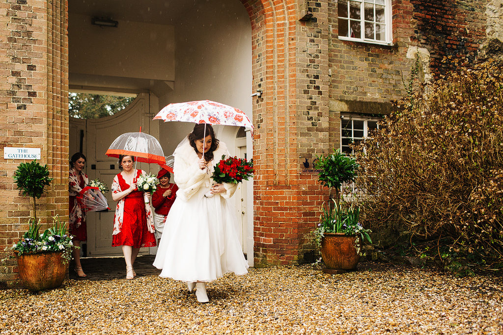 bride running in the rain at farnham castle