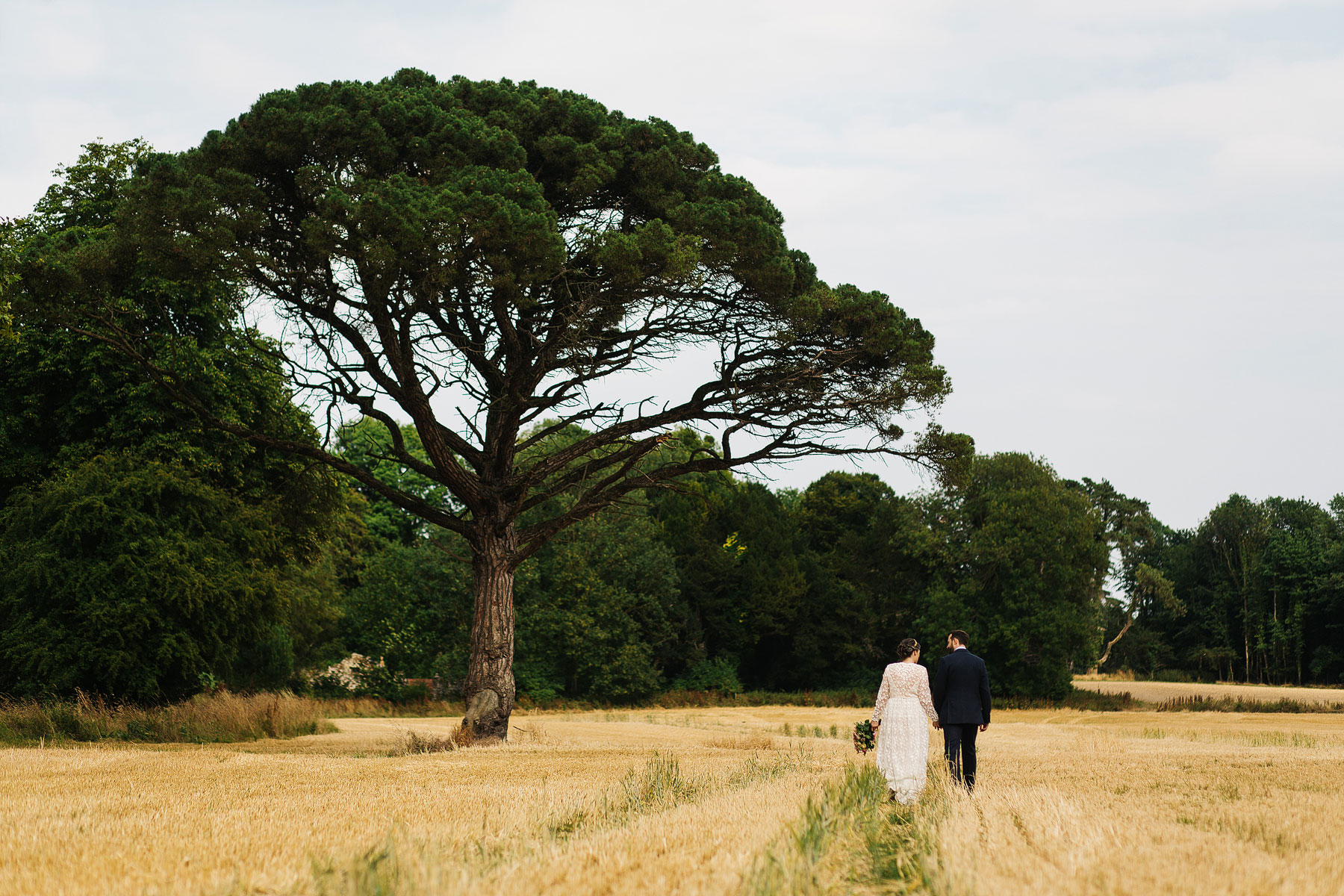 bride and groomin a field at their quirky country house wedding