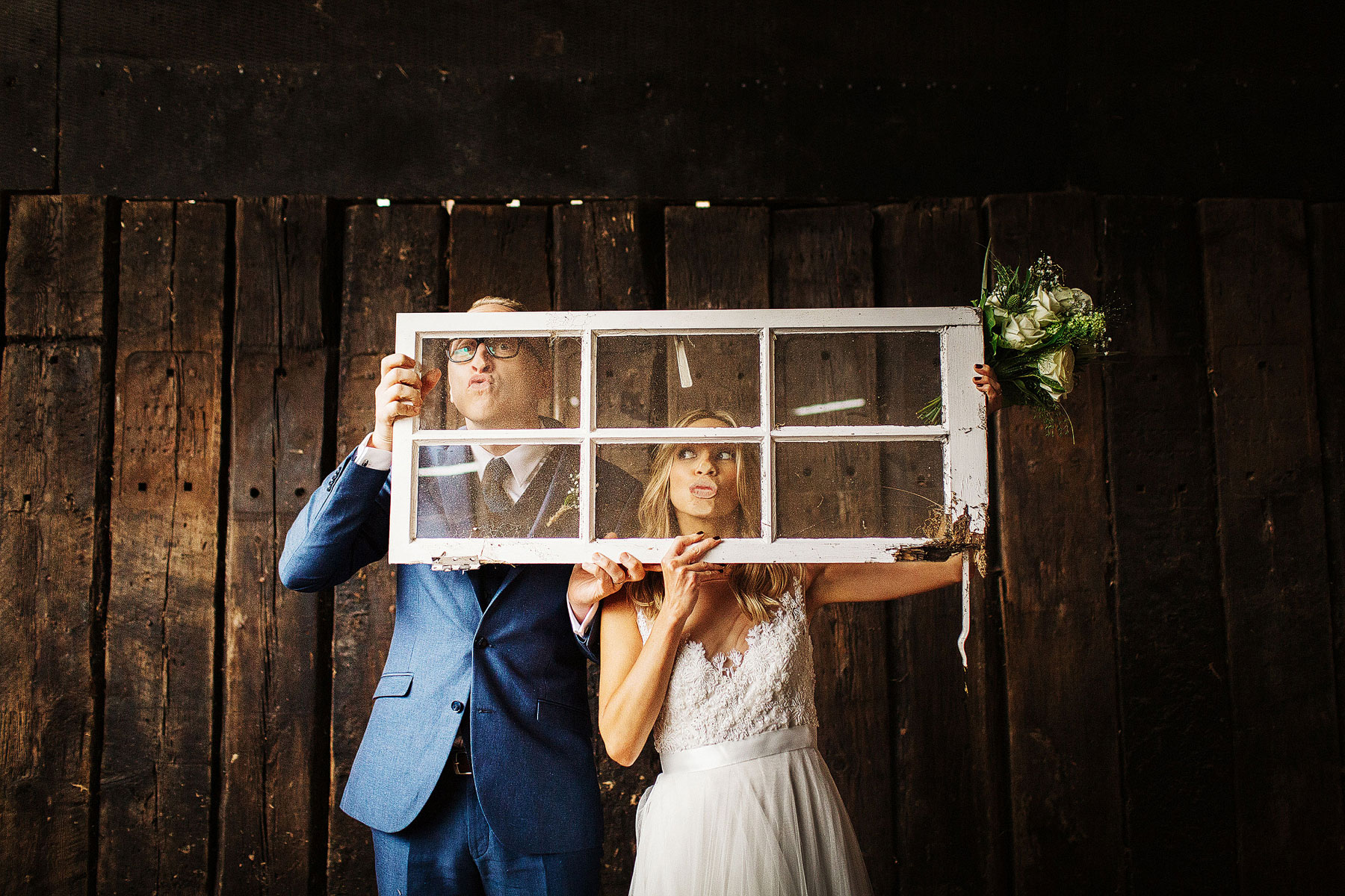 bride and groom being quirky at a barn wedding