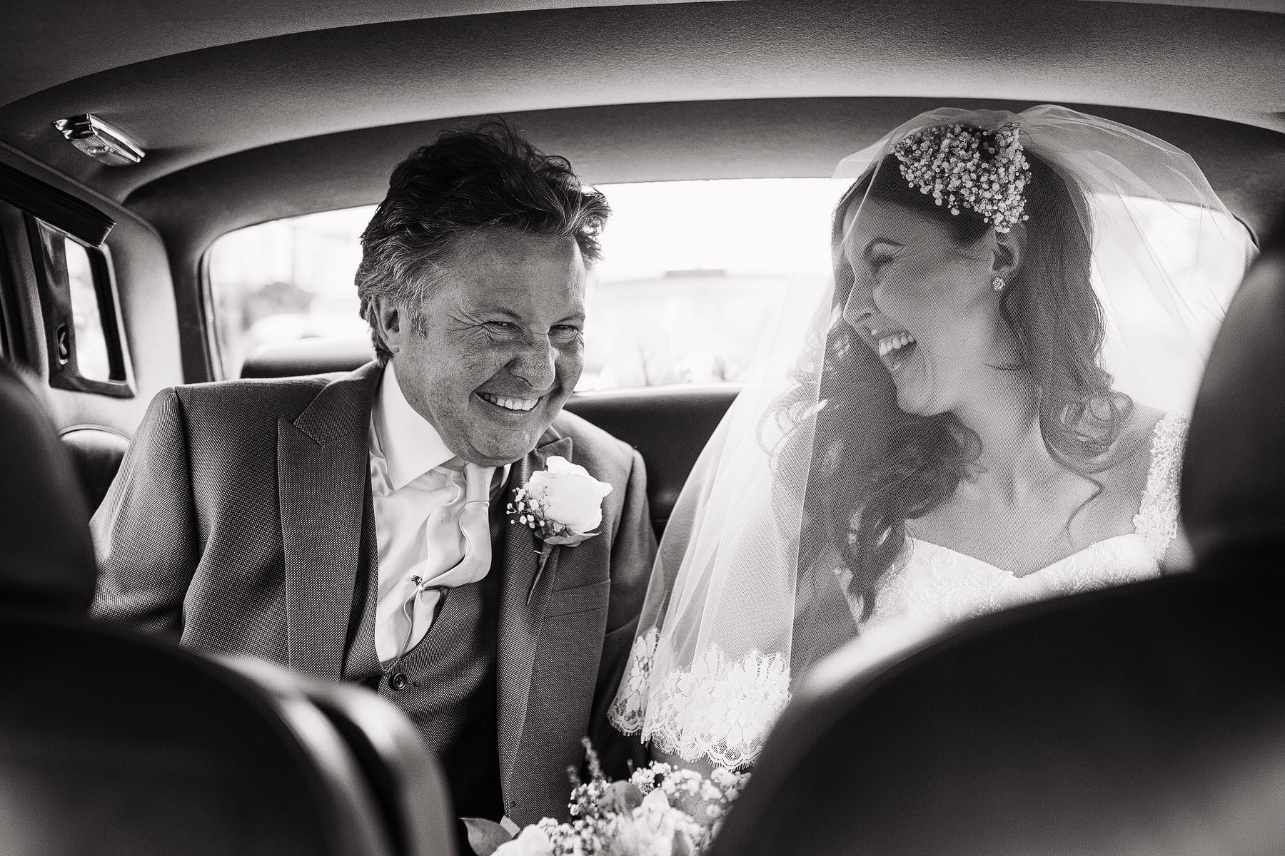 bride laughing with dad on the way to their liverpool wedding