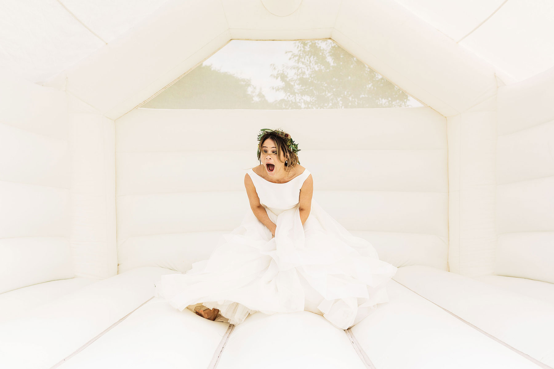 bride jumping on a bouncy castle at south farm wedding venue