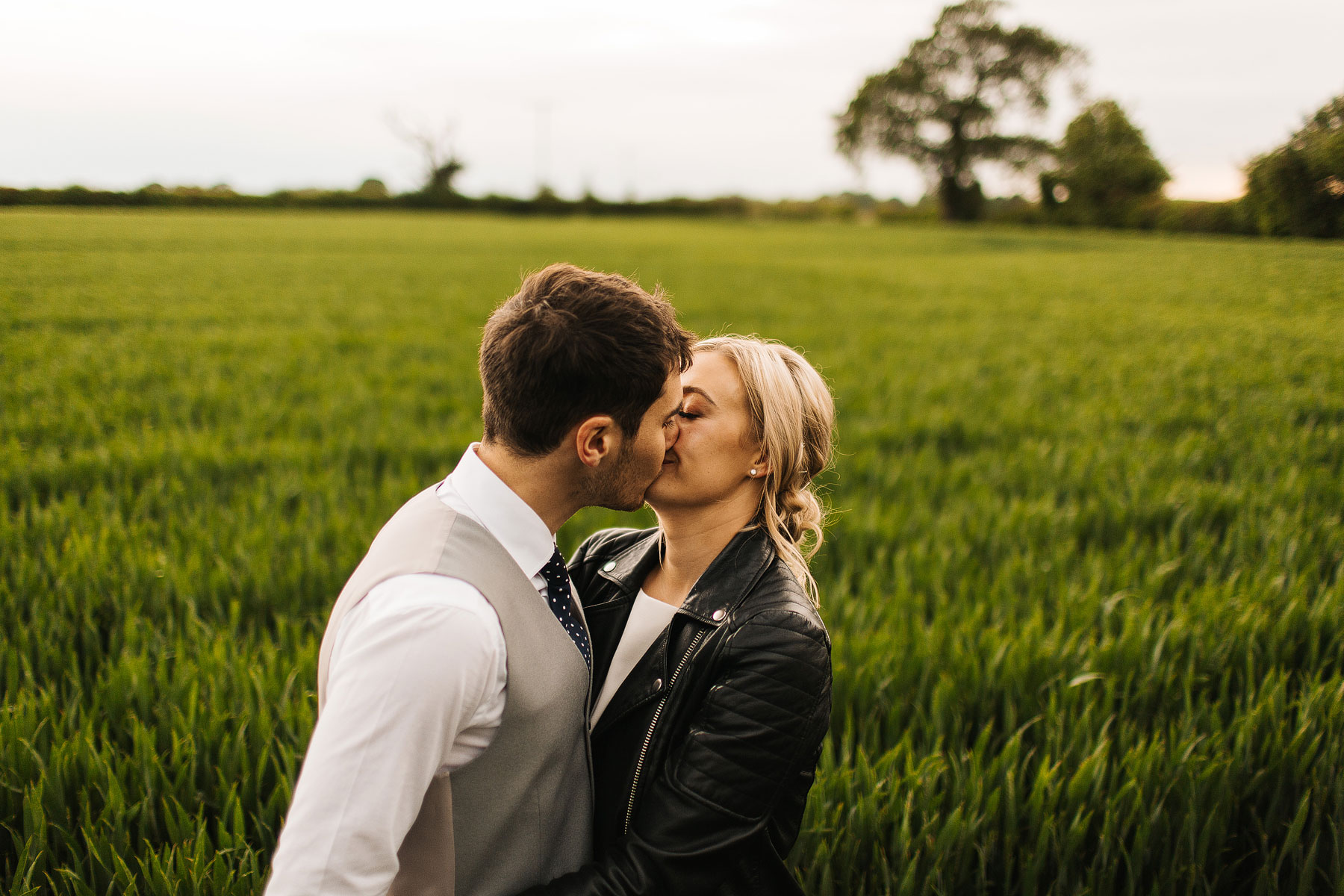 bride and groom kissing in a field in york