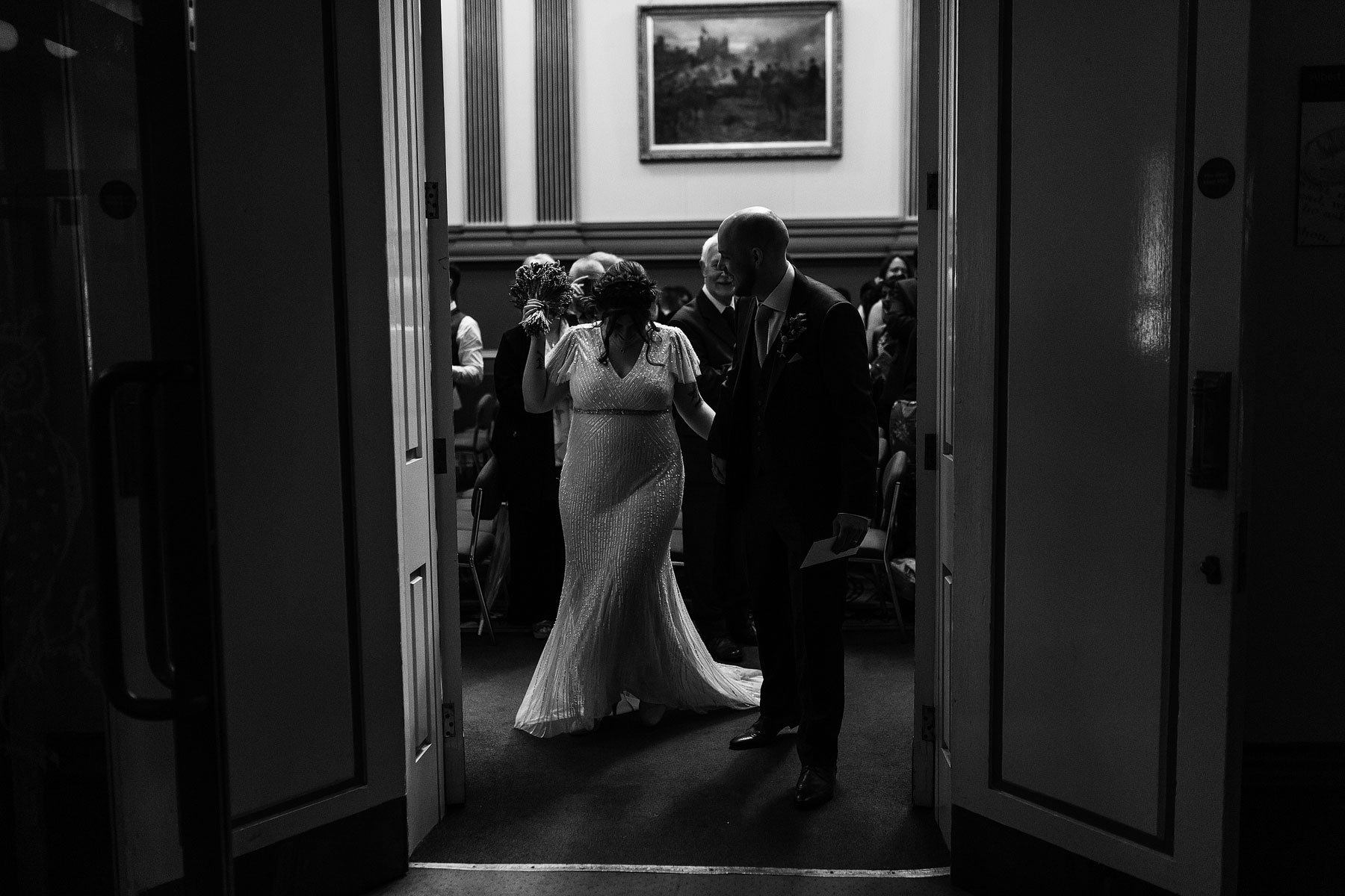 bride and groom leaving wedding ceremony at leeds civic hall