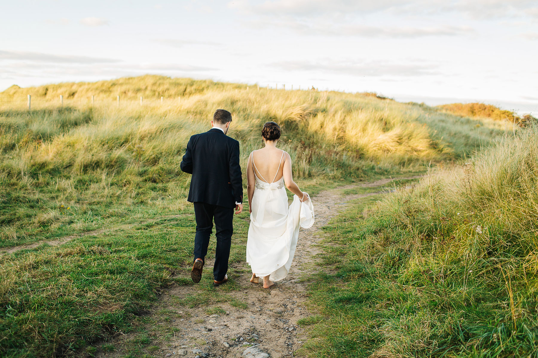 bride and groom walking on newton steads beach