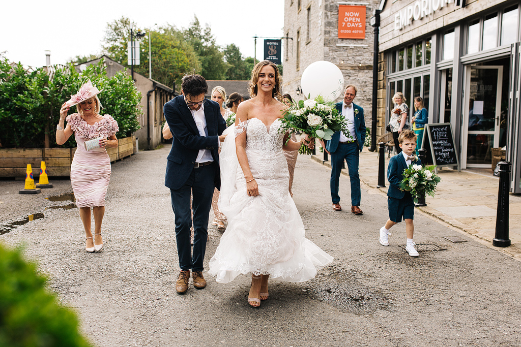 bride walking to her wedding wearing an ava rose dress at holmes mills in clitheroe