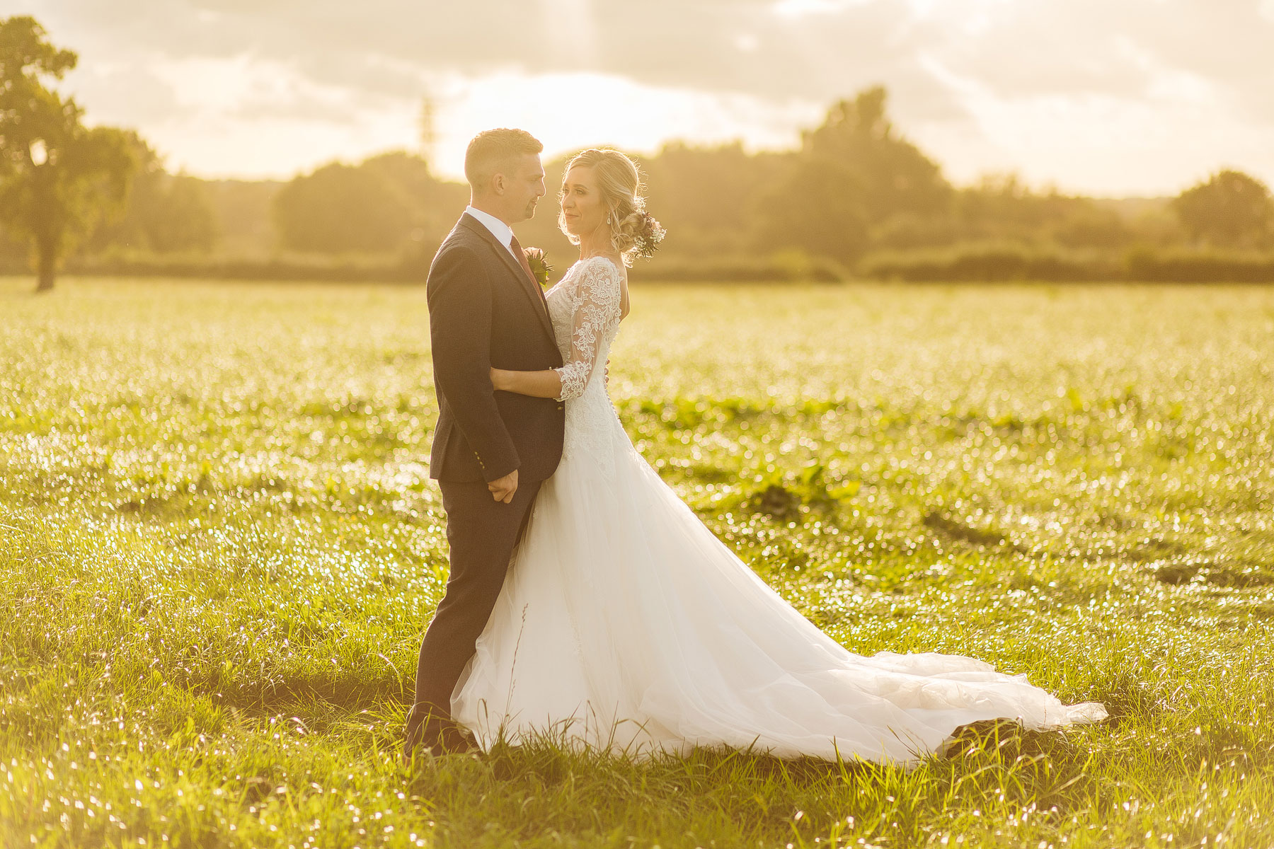 golden hour with a bride and groom in a frield in the north west