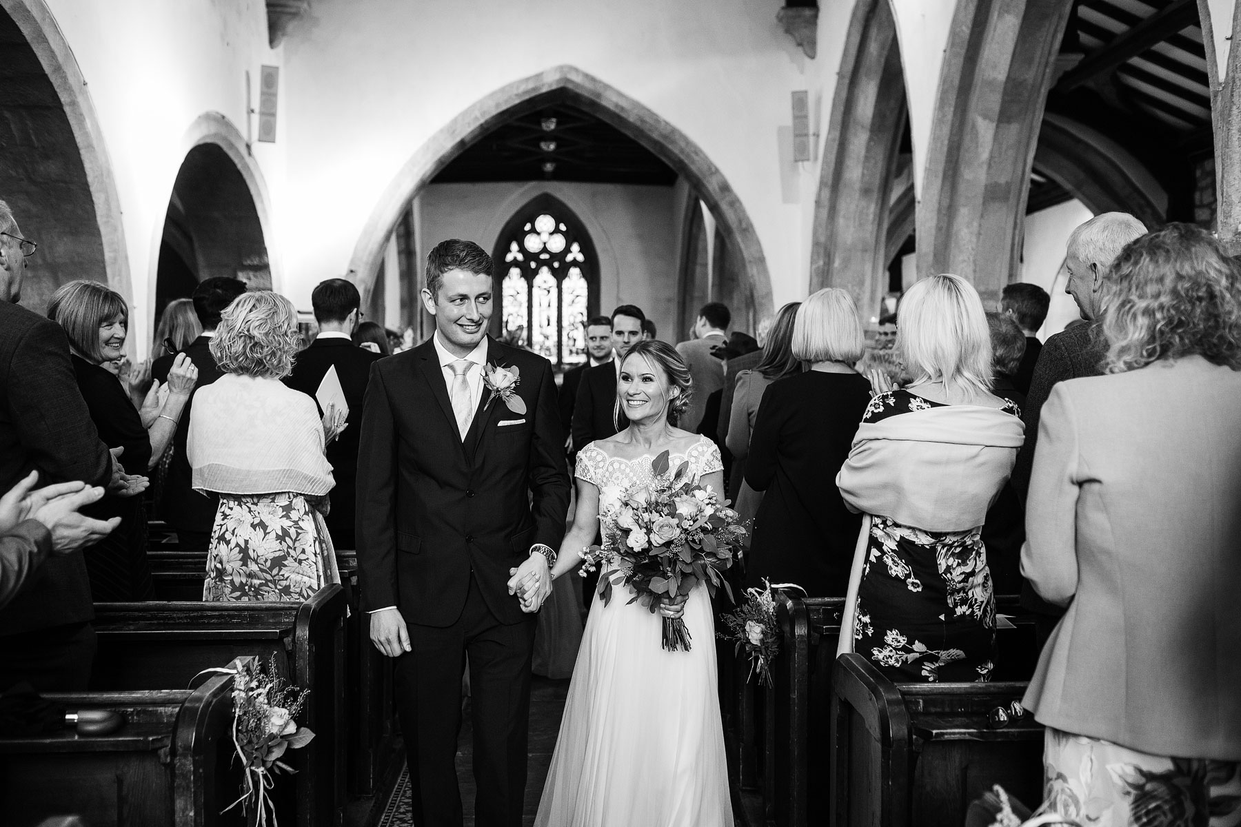 bride and groom walking out of church in grassington