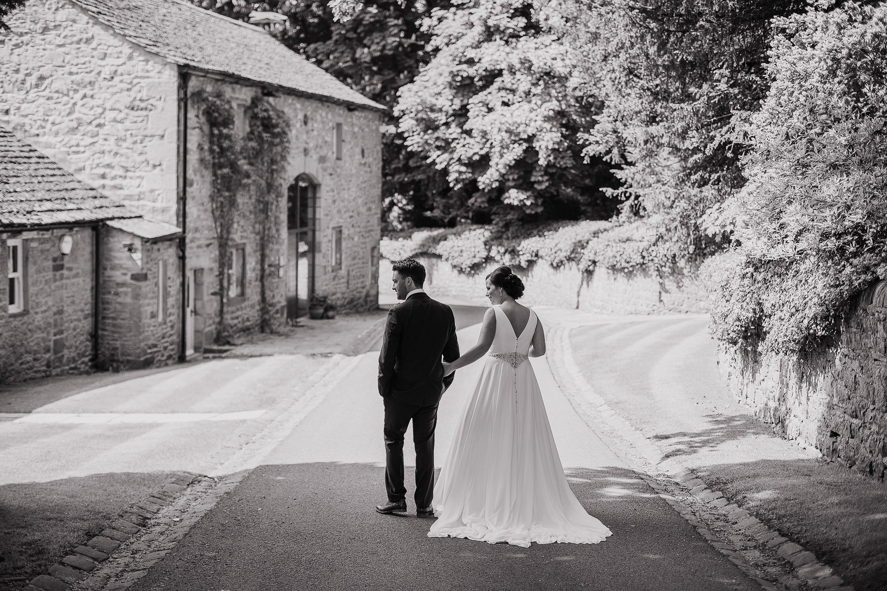 bride and groom walking through the estate of broughton hall