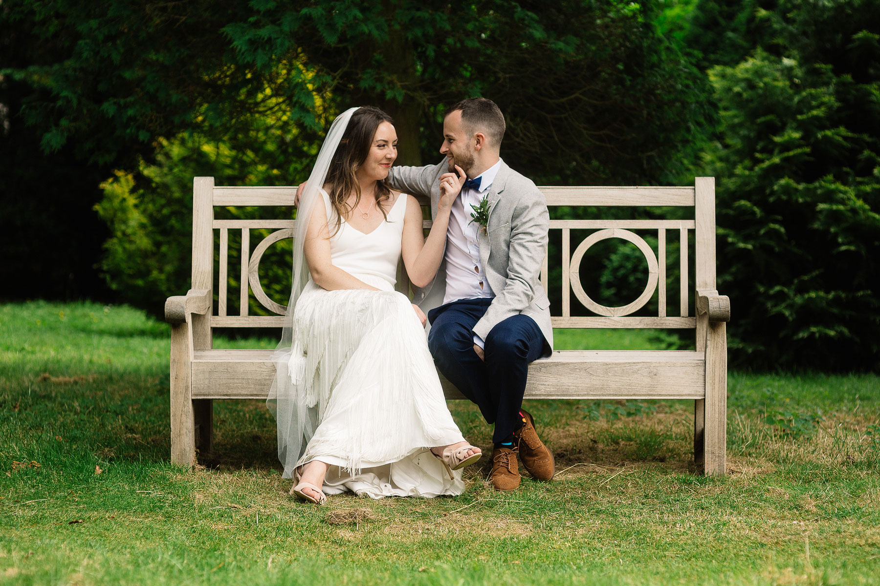 bride and groom sitting in the grounds of the broughton hall estate