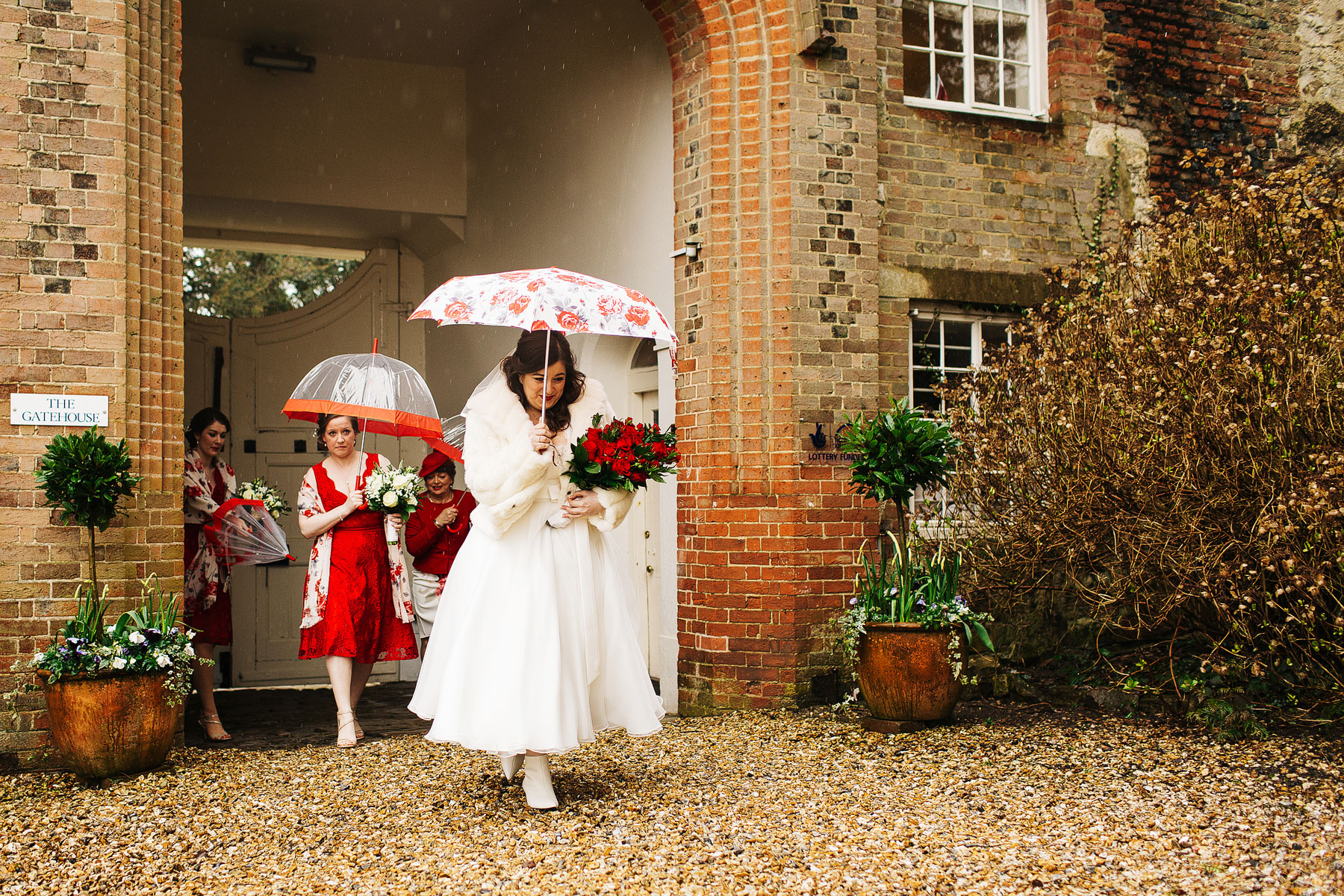 bride walking in the rain at farnham castle