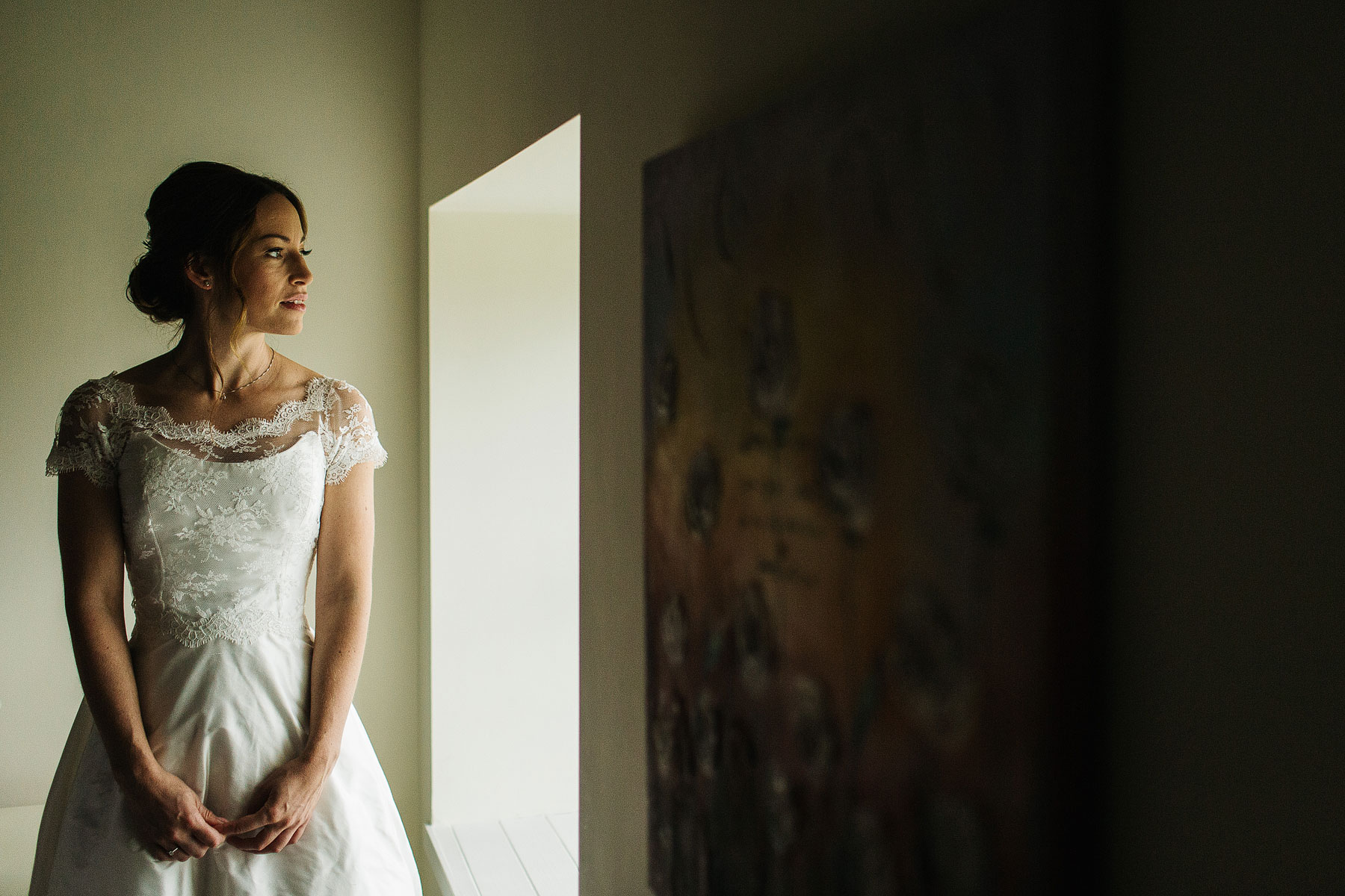 bride looking out of the window waiting for her informal wedding to start