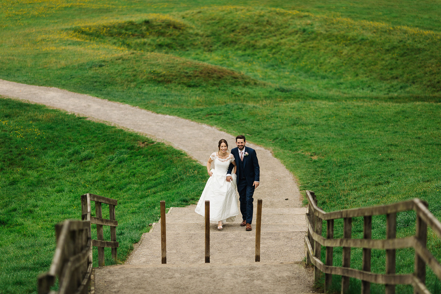 bride and groom walking on the grounds of bolton abbey