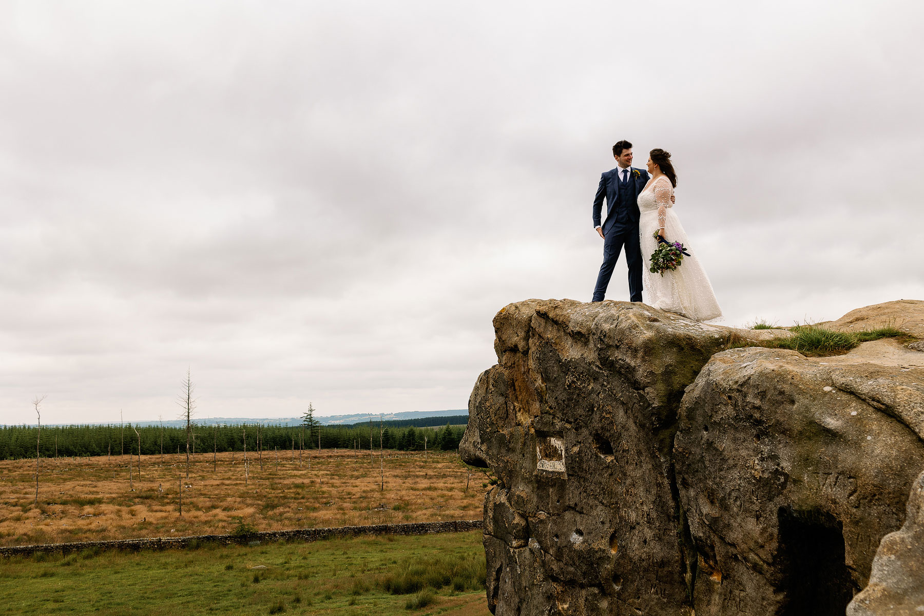 couple on a rock in the yorkshire countryside just married