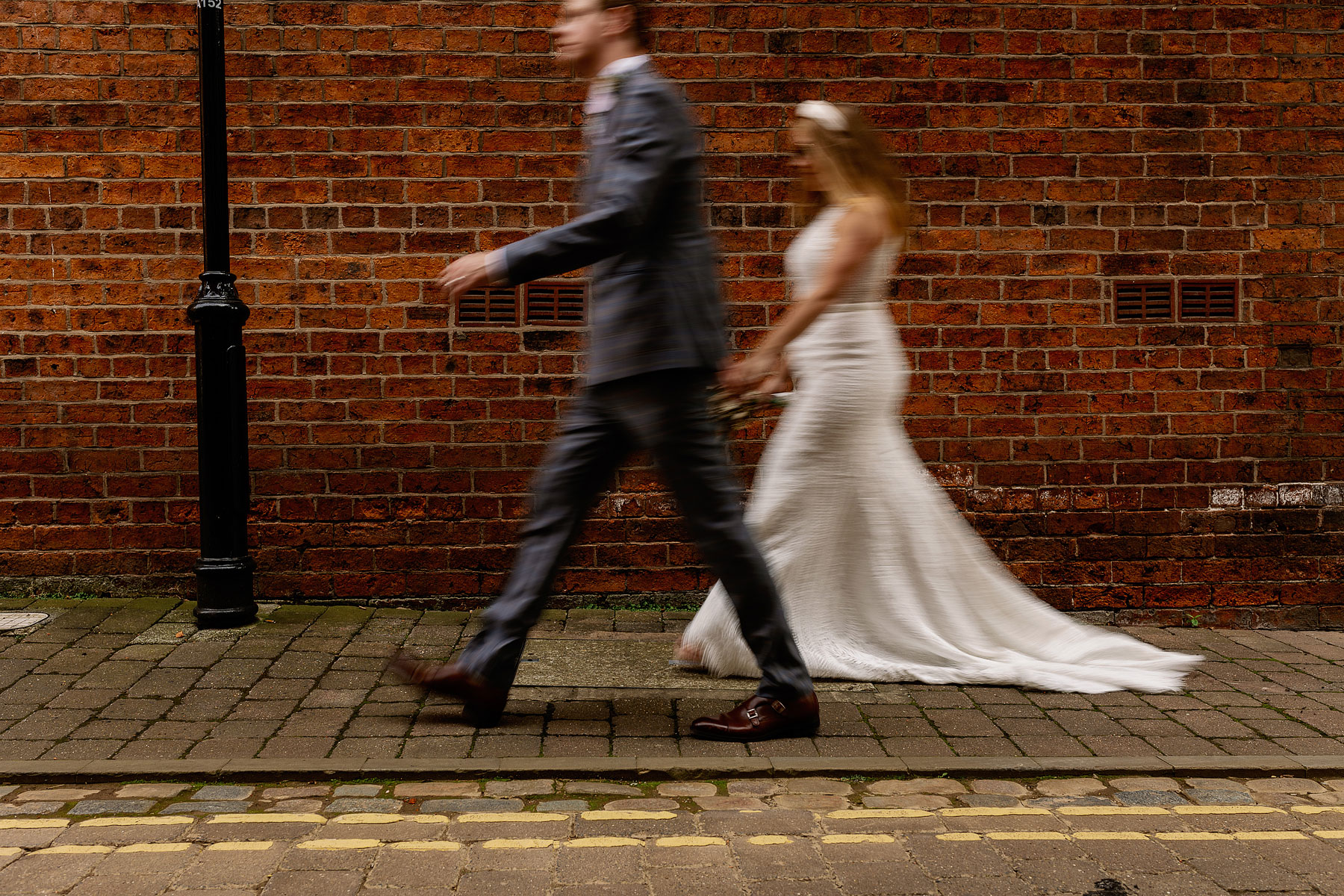 arty shot of a bride and groom walking in leeds