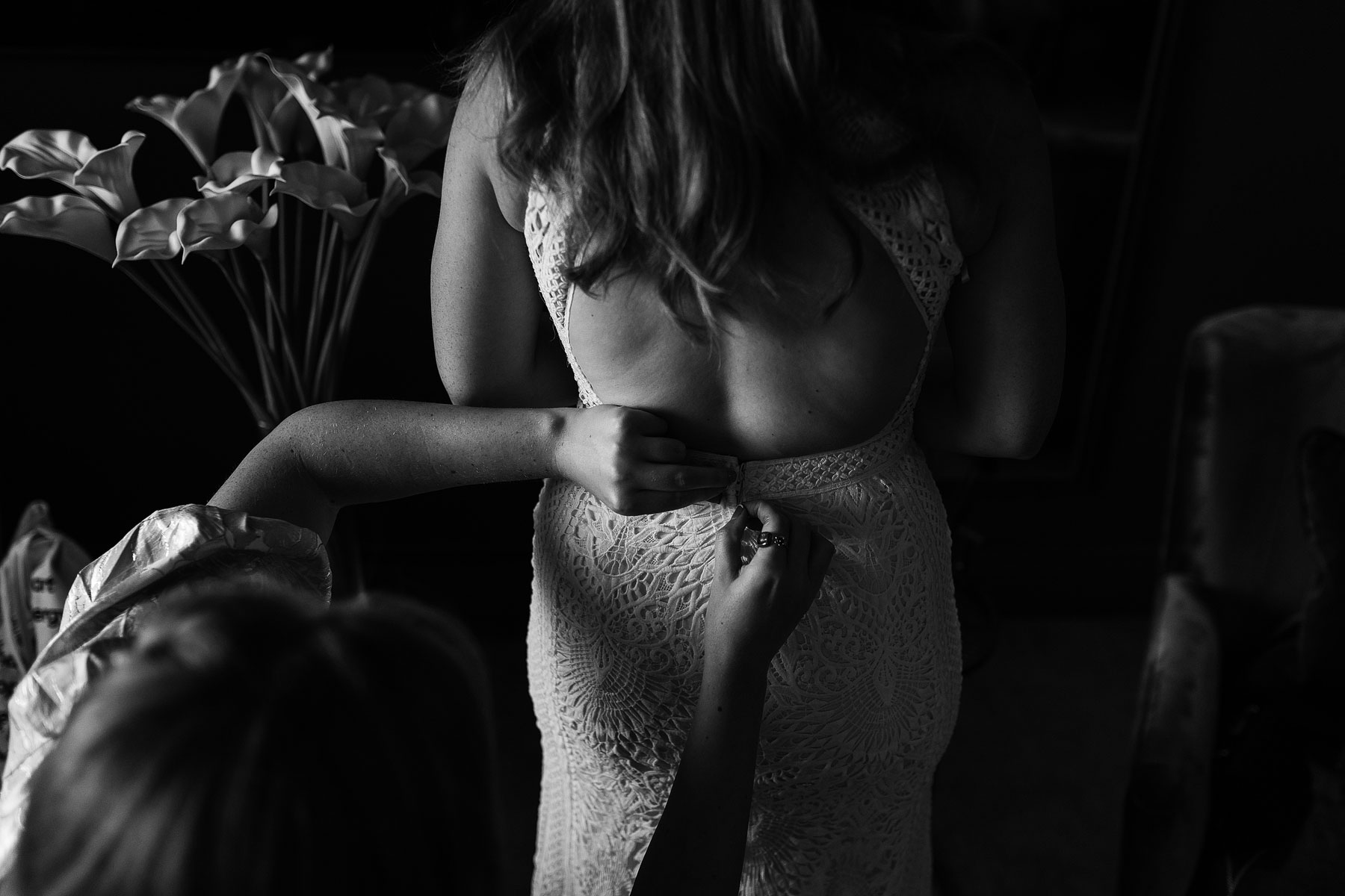 buttoning up of a wedding dress during bridal prep