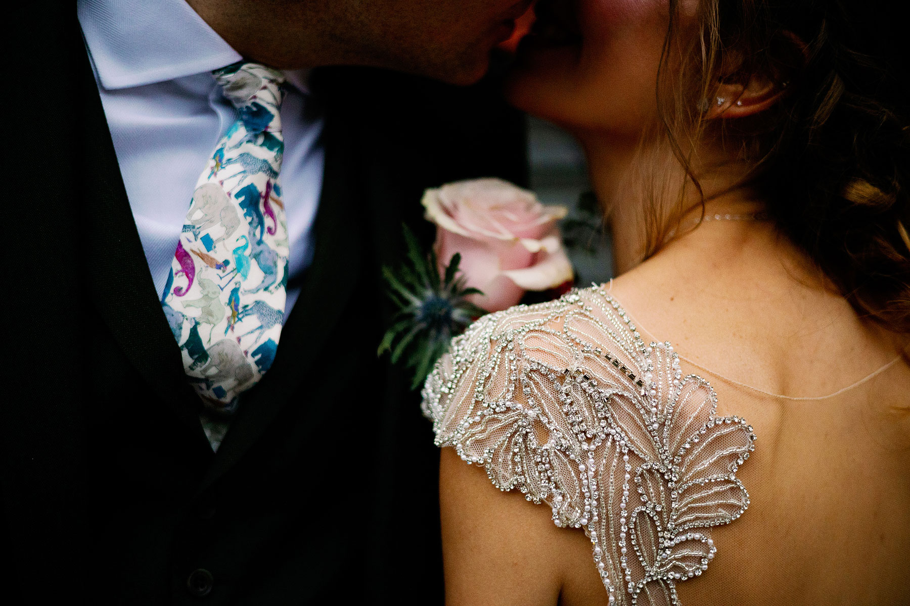 sparkle trim on a brides dress with a jungle effect tie on a groom