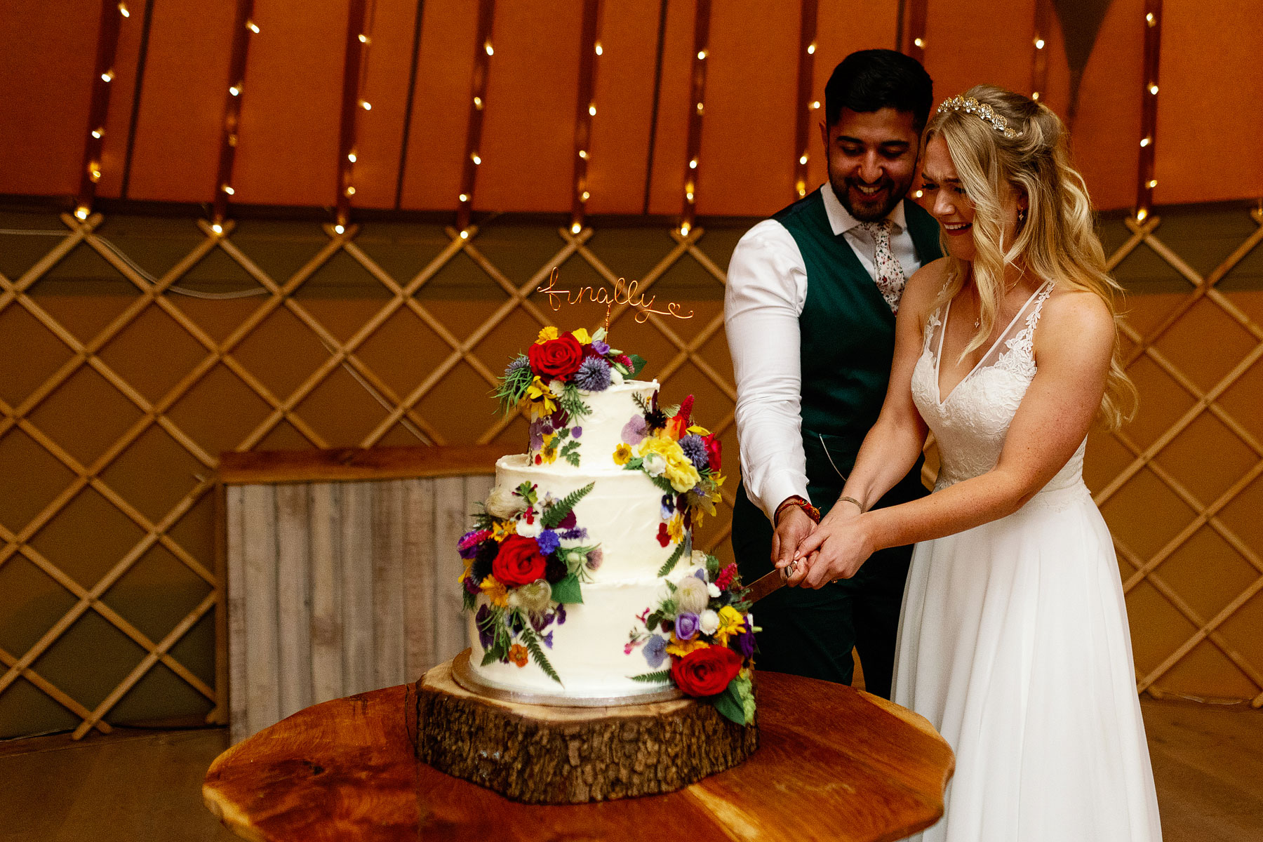 colurful and beautiful wedding cake ideas with a bride and groom cutting cake