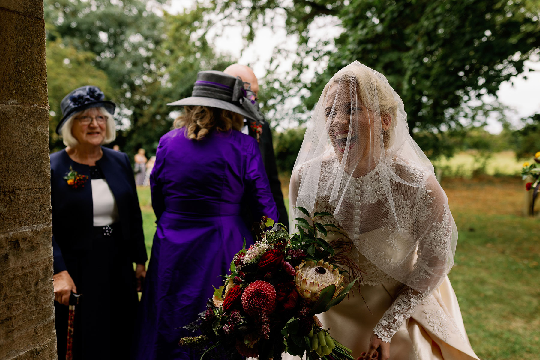 happy bride at church with her stunning autumn bouquet