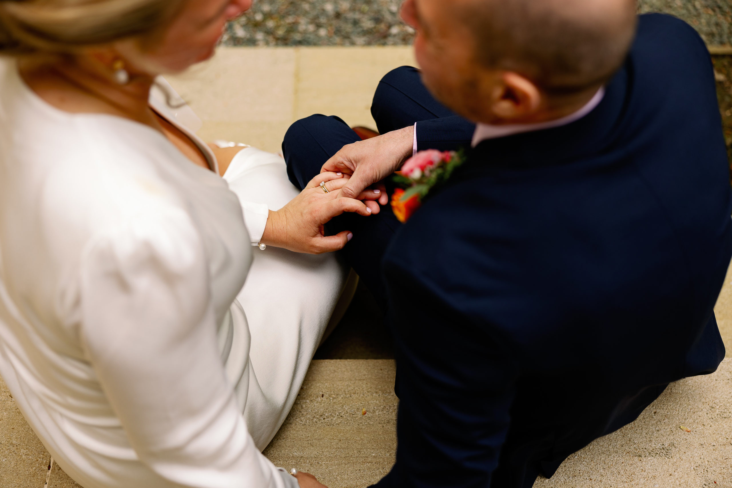 Bride and groom holding hands showing wedding ring