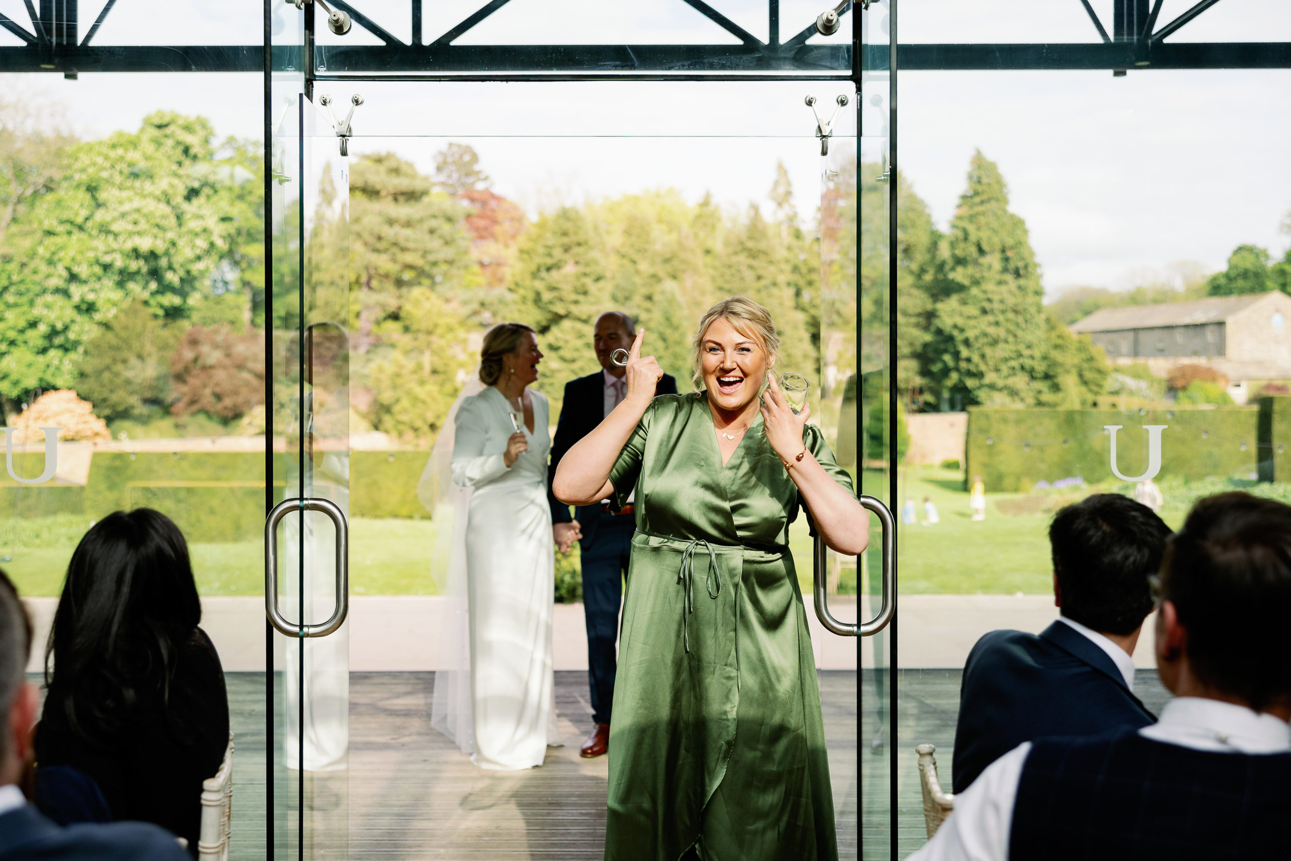 Adult bridesmaid laughing wearing a green dress