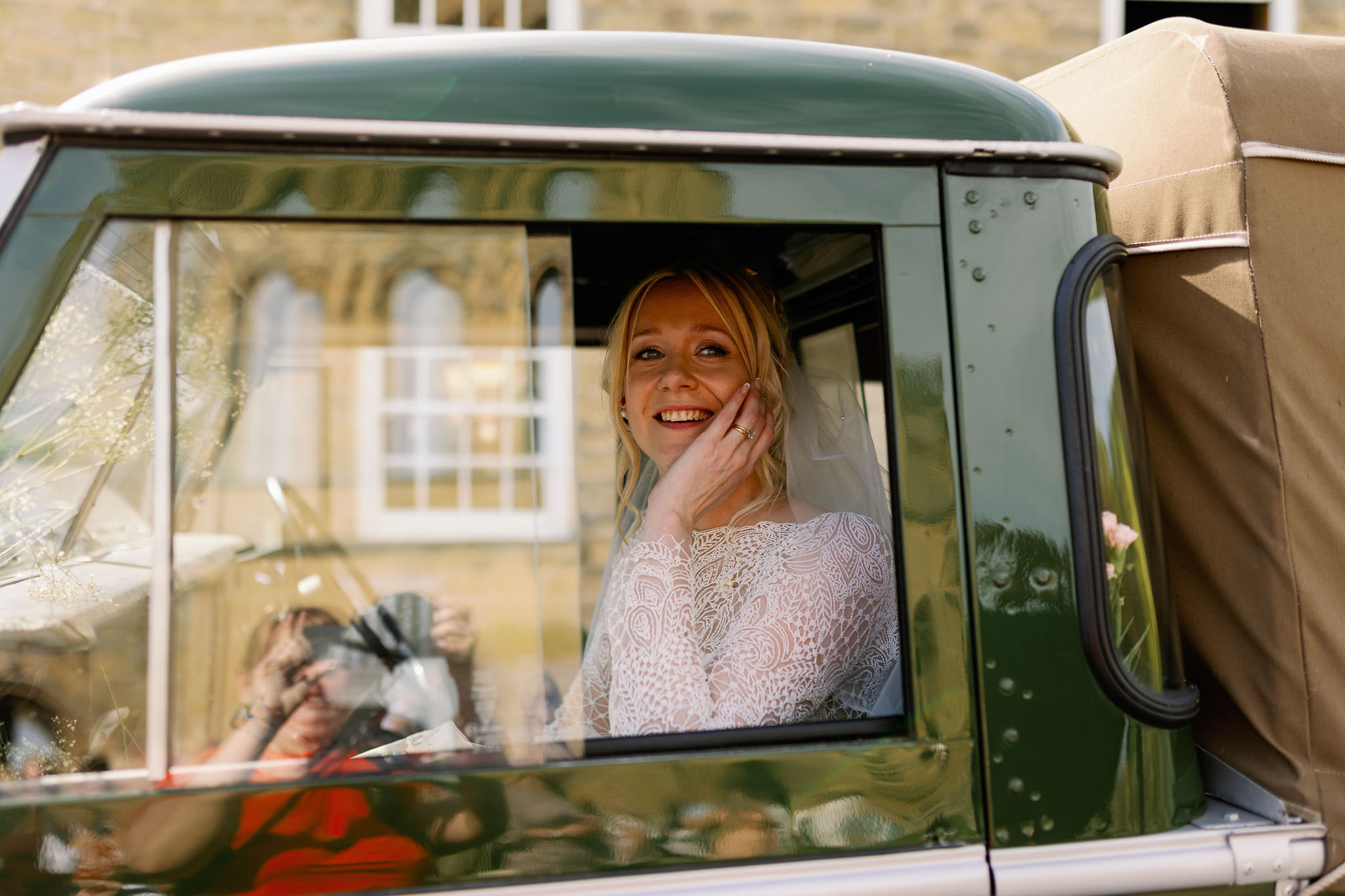 Bride driving in a Landrover from her outdoors Wedding 