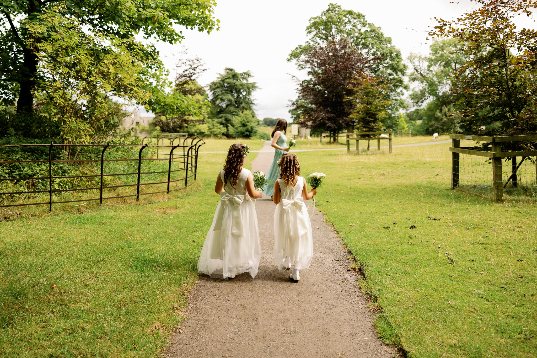 Bridesmaids walking to wedding ceremony outdoors in North Yorkshire 