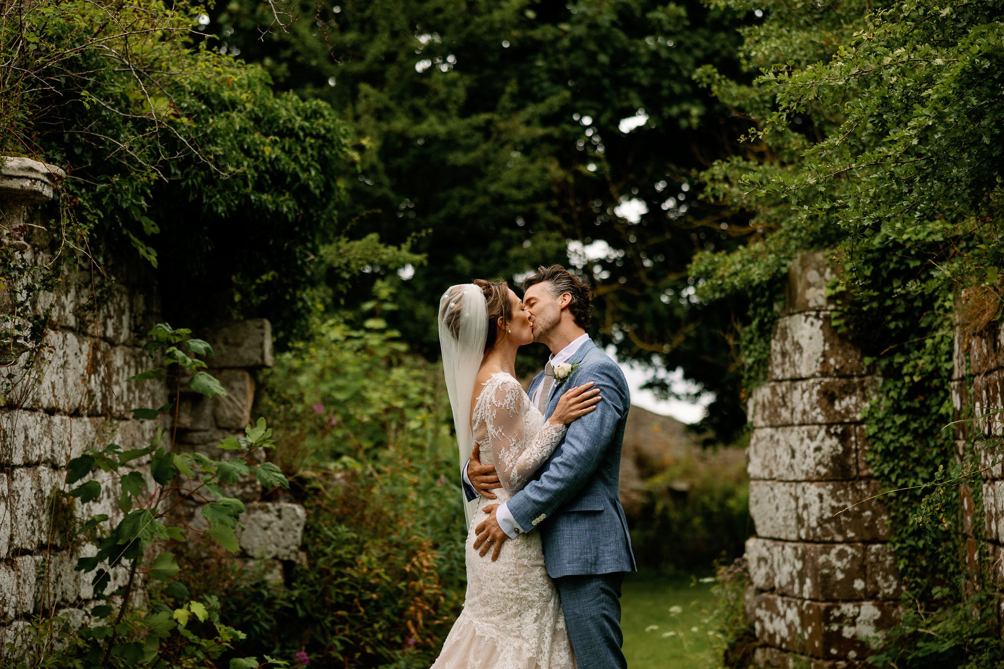 Bride and groom kissing in the ruins of Jervaulx Abbey