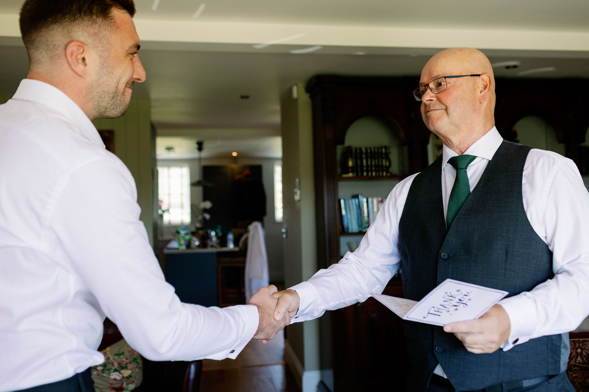 Dad and son in law exchanging gifts on wedding day 